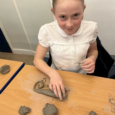 Children making clay lizards